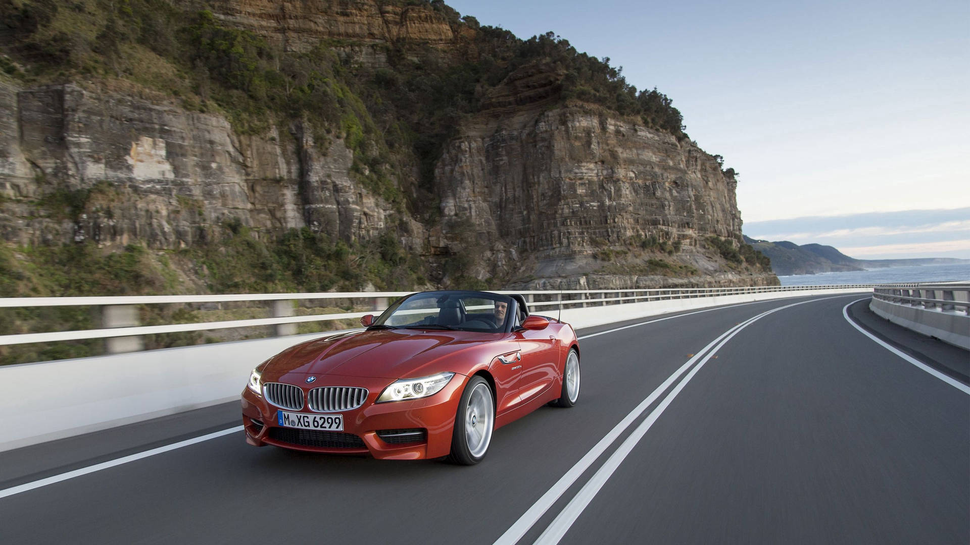 วอลเปเปอร์รถ BMW Z4 สีส้มบนถนนข้างภูเขา — Bmw วอลเปเปอร์