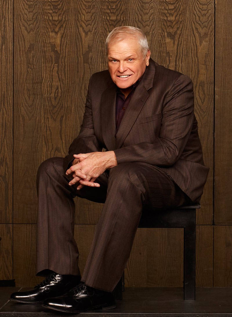 Brian Dennehy ชุดสูทสีน้ำตาลสไตล์สวยงาม พื้นหลังไม้ วอลเปเปอร์