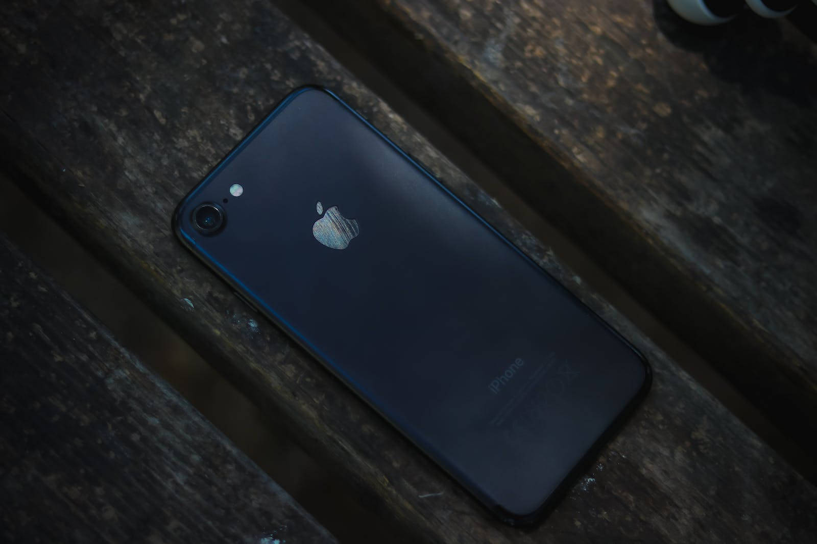 iPhone 7 สีเข้มบนไม้ วอลเปเปอร์