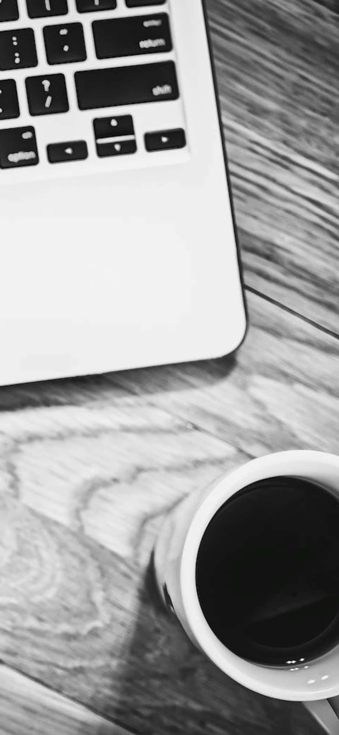 พื้นหลังโต๊ะ iPhone X ภาพขาวดำพร้อมถ้วยกาแฟและแล็ปท็อป วอลเปเปอร์