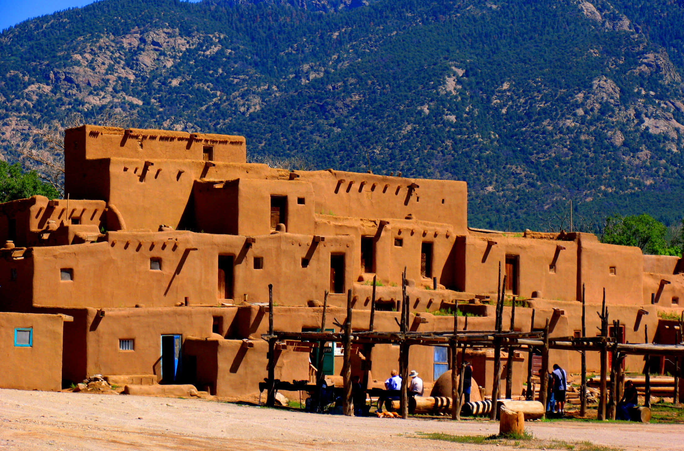 คำบรรยาย: "เที่ยงวันอันงดงามที่ Taos Pueblo อันเก่าแก่" วอลเปเปอร์