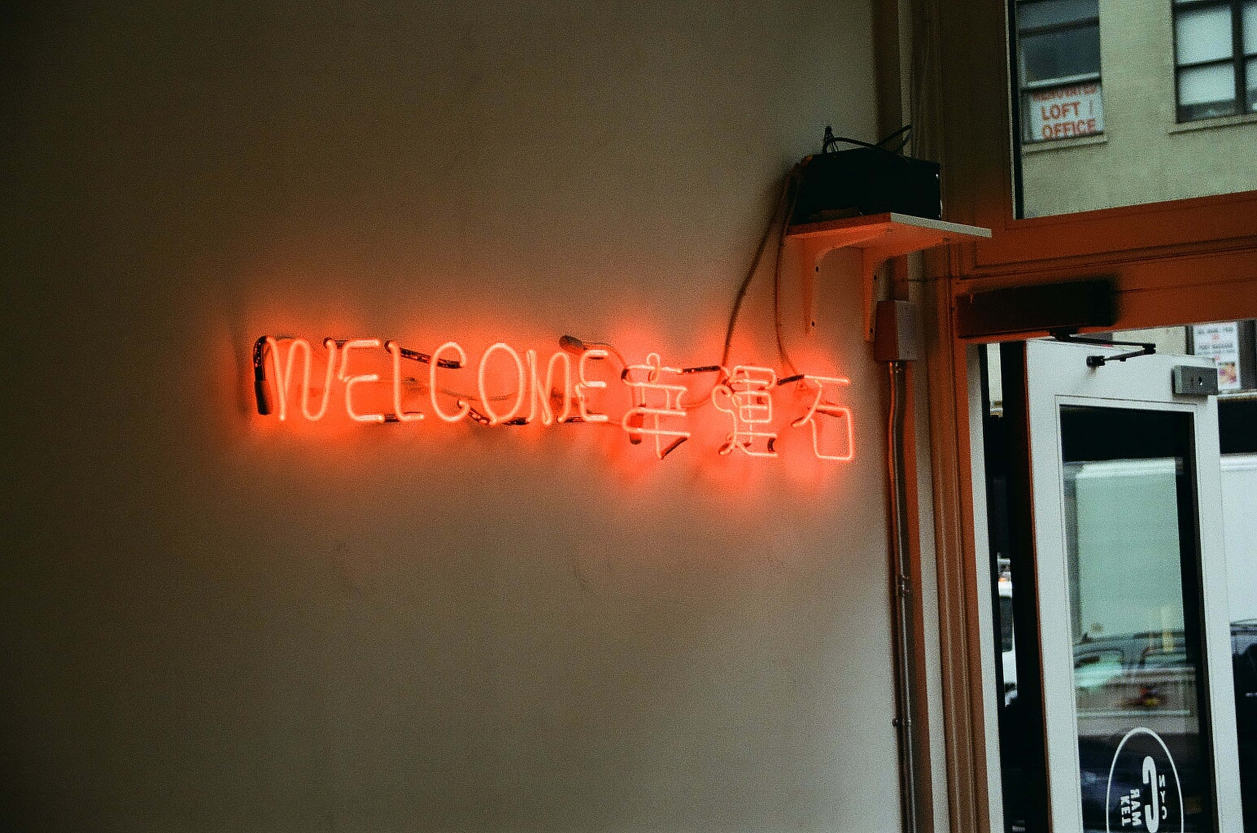 ป้ายนีออนที่เขียนว่า welcome บนผนัง วอลเปเปอร์