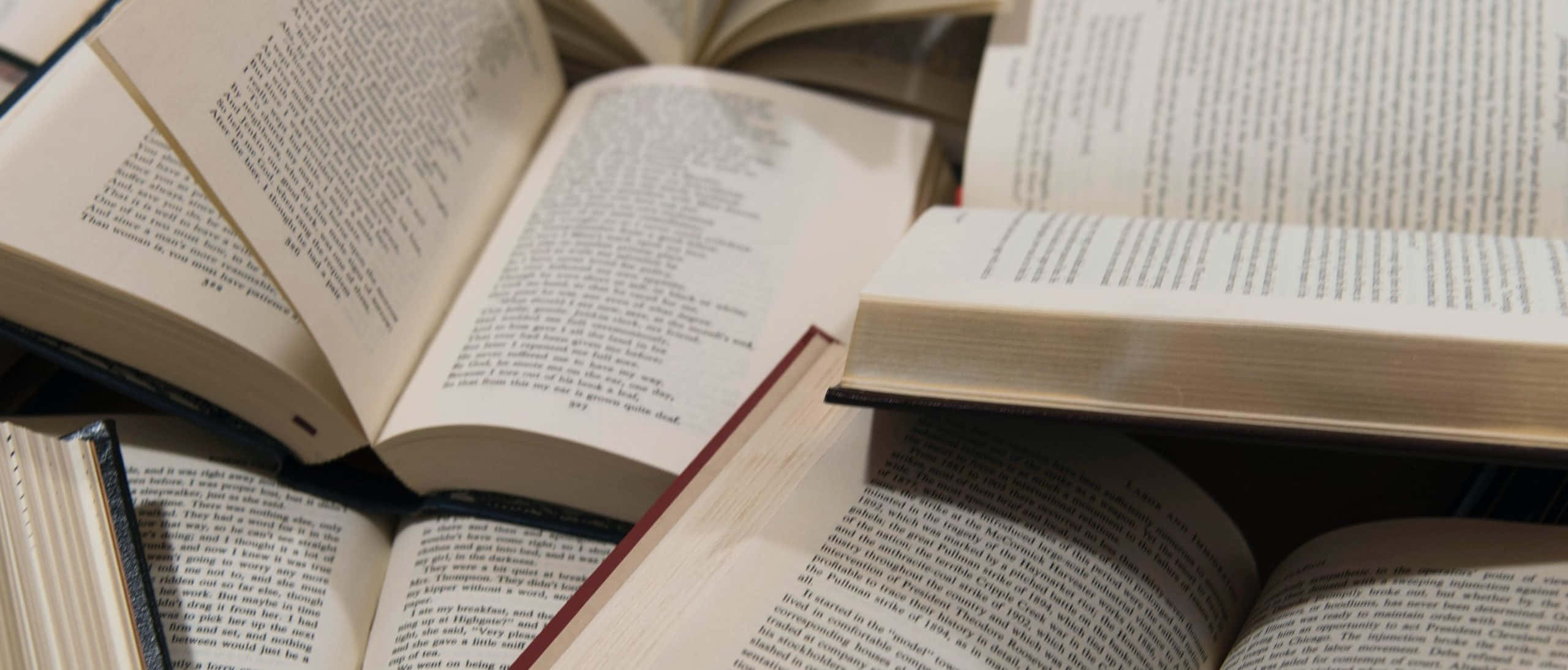 กองหนังสือบนโต๊ะ วอลเปเปอร์