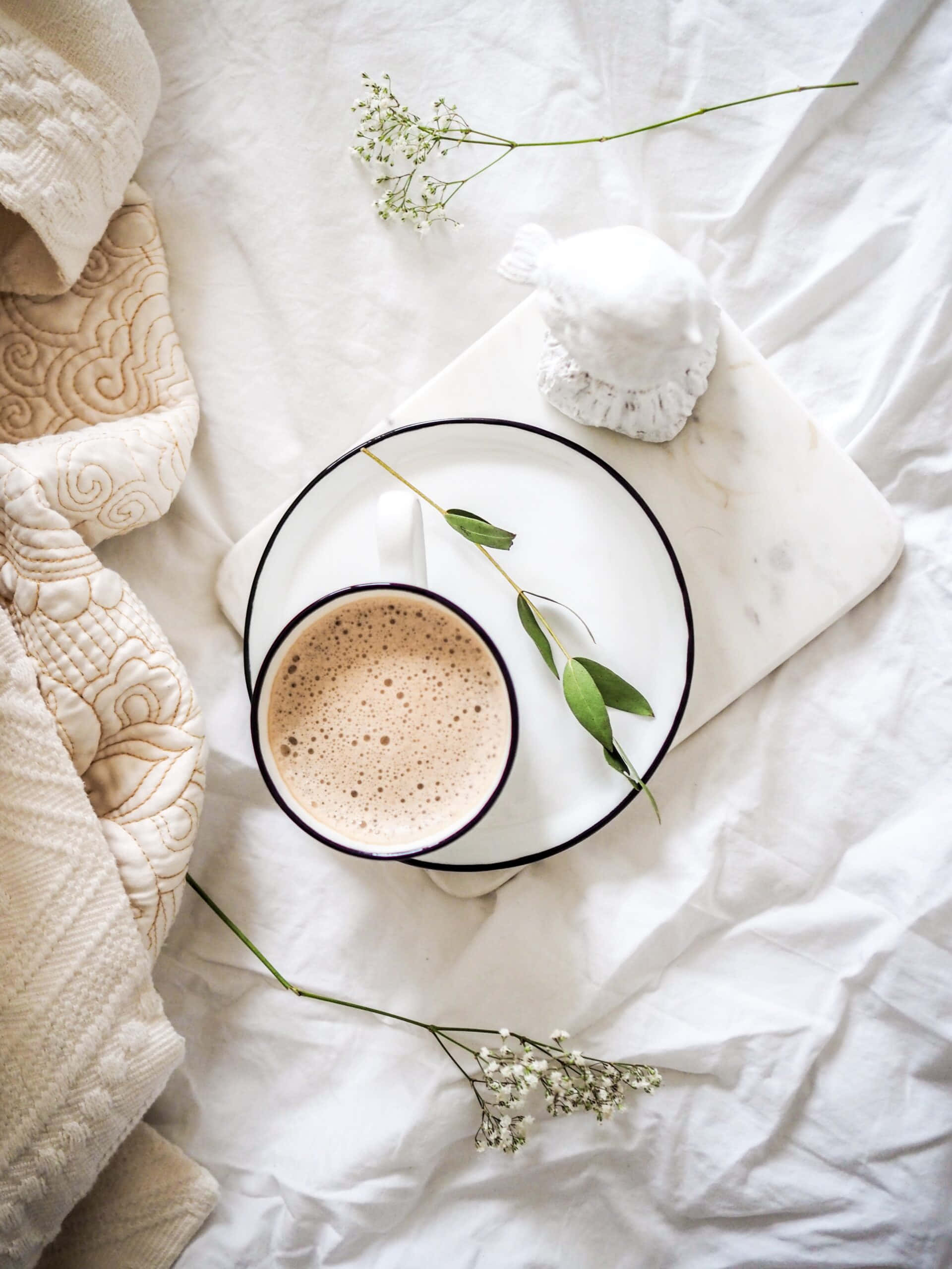 กาแฟหนึ่งถ้วยบนเตียงพร้อมดอกไม้ วอลเปเปอร์