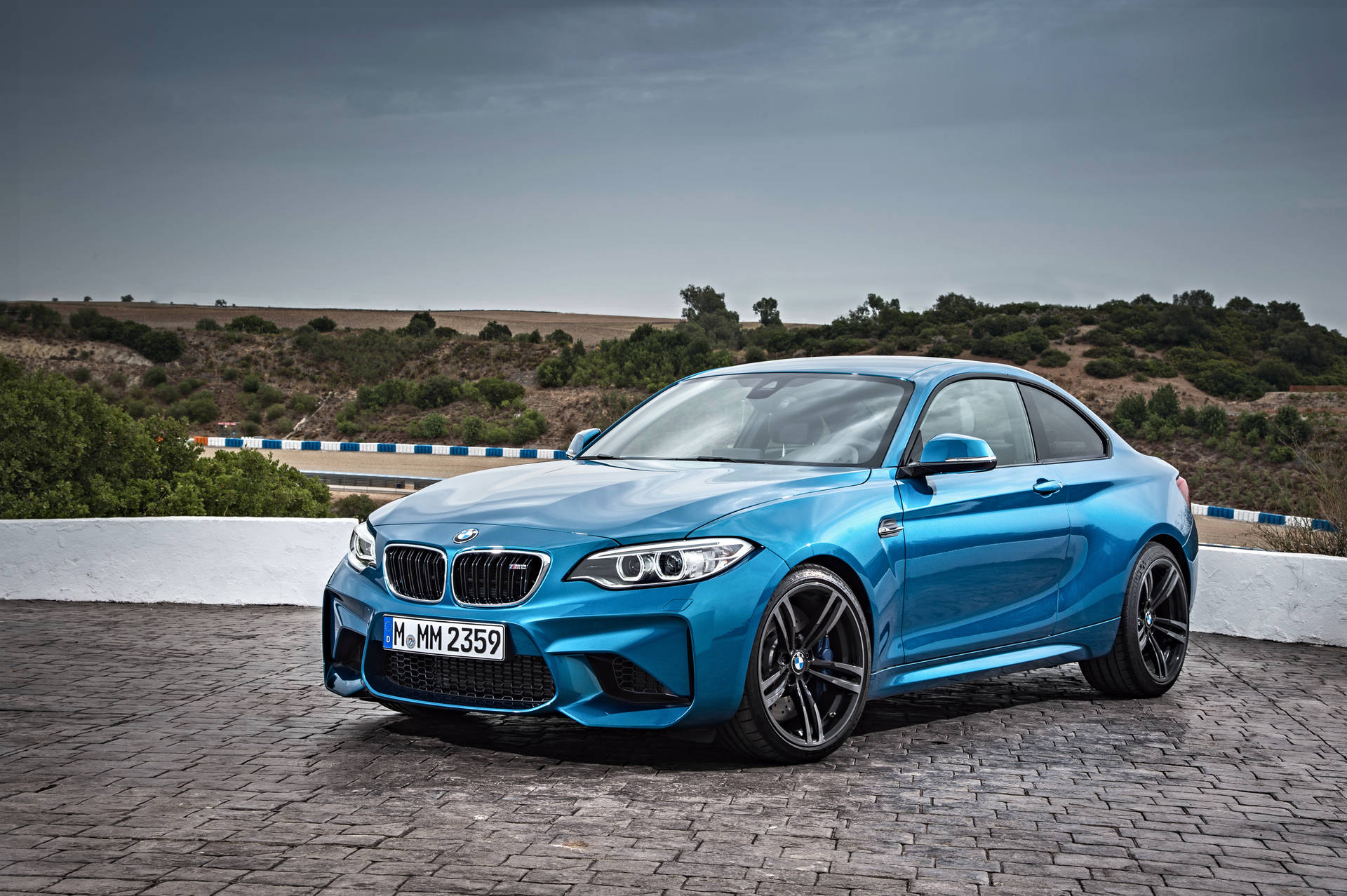 วอลเปเปอร์ BMW F87 สีฟ้าบนพื้นถนนพร้อมวิวภูเขา — Bmw วอลเปเปอร์
