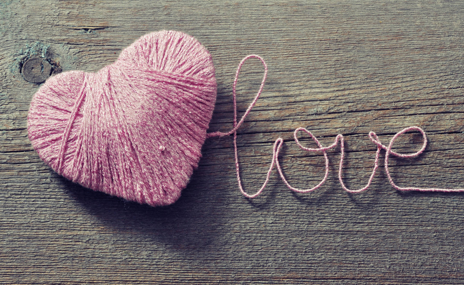คำว่า "Love" ที่โรแมนติกเขียนด้วยเชือกสีชมพูเป็นรูปหัวใจบนโต๊ะไม้ สำหรับวันวาเลนไทน์ — ความรัก วอลเปเปอร์