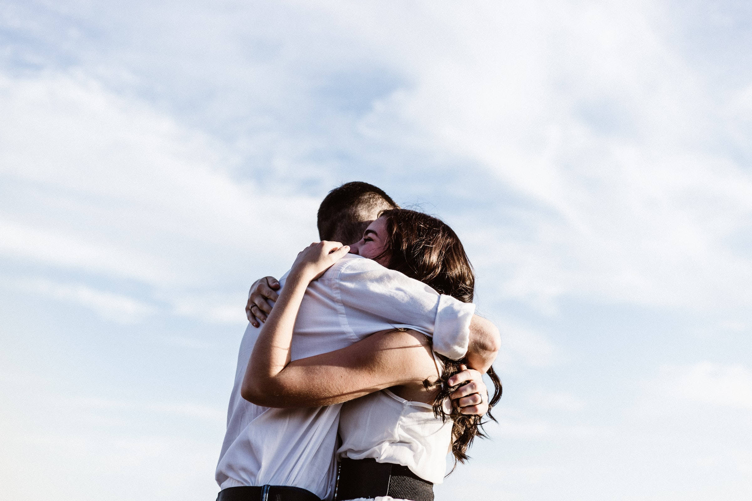 คู่รักกอดกันอย่างอบอุ่นในวันที่มีแดดจ้า วอลเปเปอร์