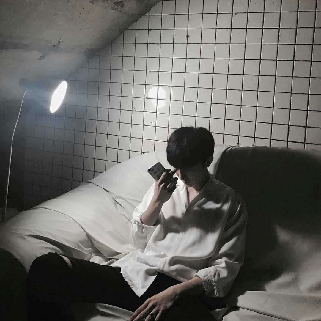 ชายคนหนึ่งนั่งบนเตียง วอลเปเปอร์