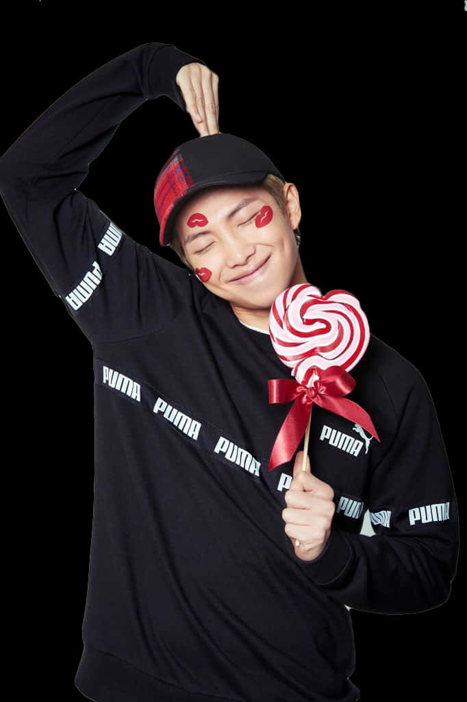 ชายยิ้มถืออมยิ้มและสติ๊กเกอร์รูปหัวใจ วอลเปเปอร์