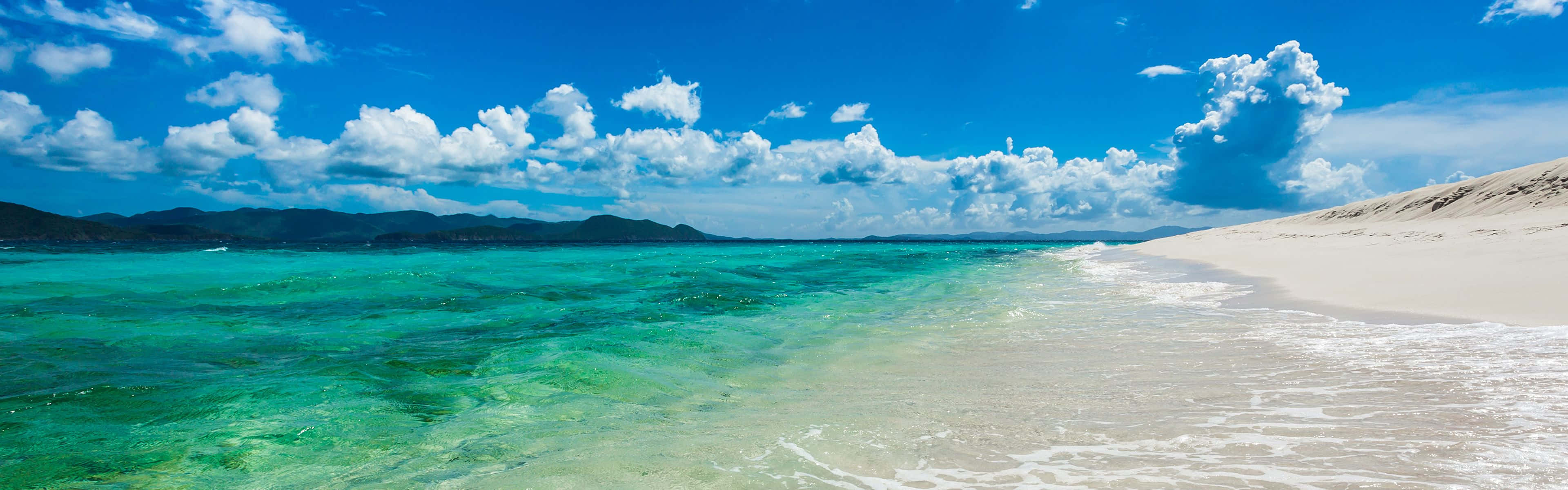 ชายหาดที่มีน้ำใสและทรายขาว วอลเปเปอร์