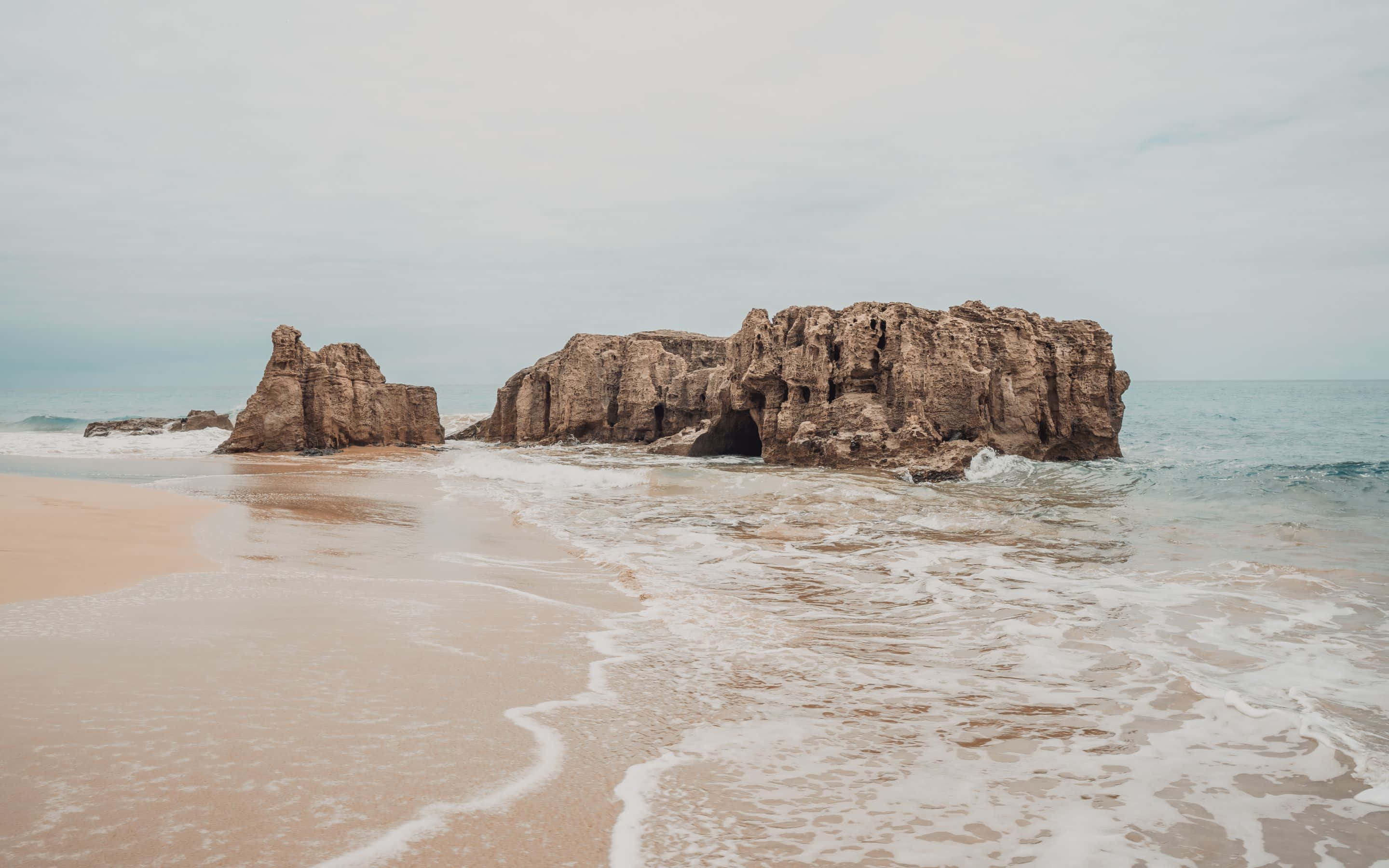 ชายหาดที่มีหินและคลื่น วอลเปเปอร์
