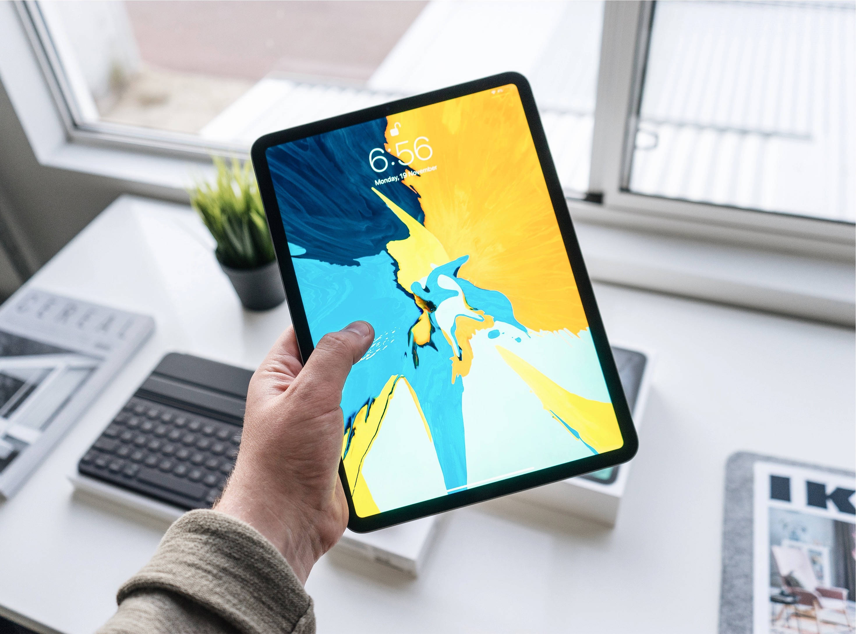 บุคคลถือ Apple iPad Pro วอลเปเปอร์