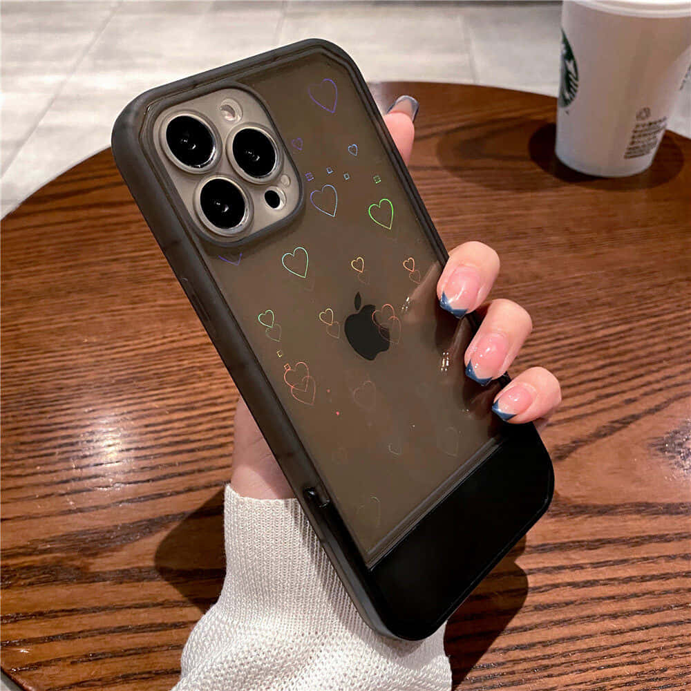 ผู้หญิงถือเคส iPhone 11 ที่มีลายหัวใจ วอลเปเปอร์