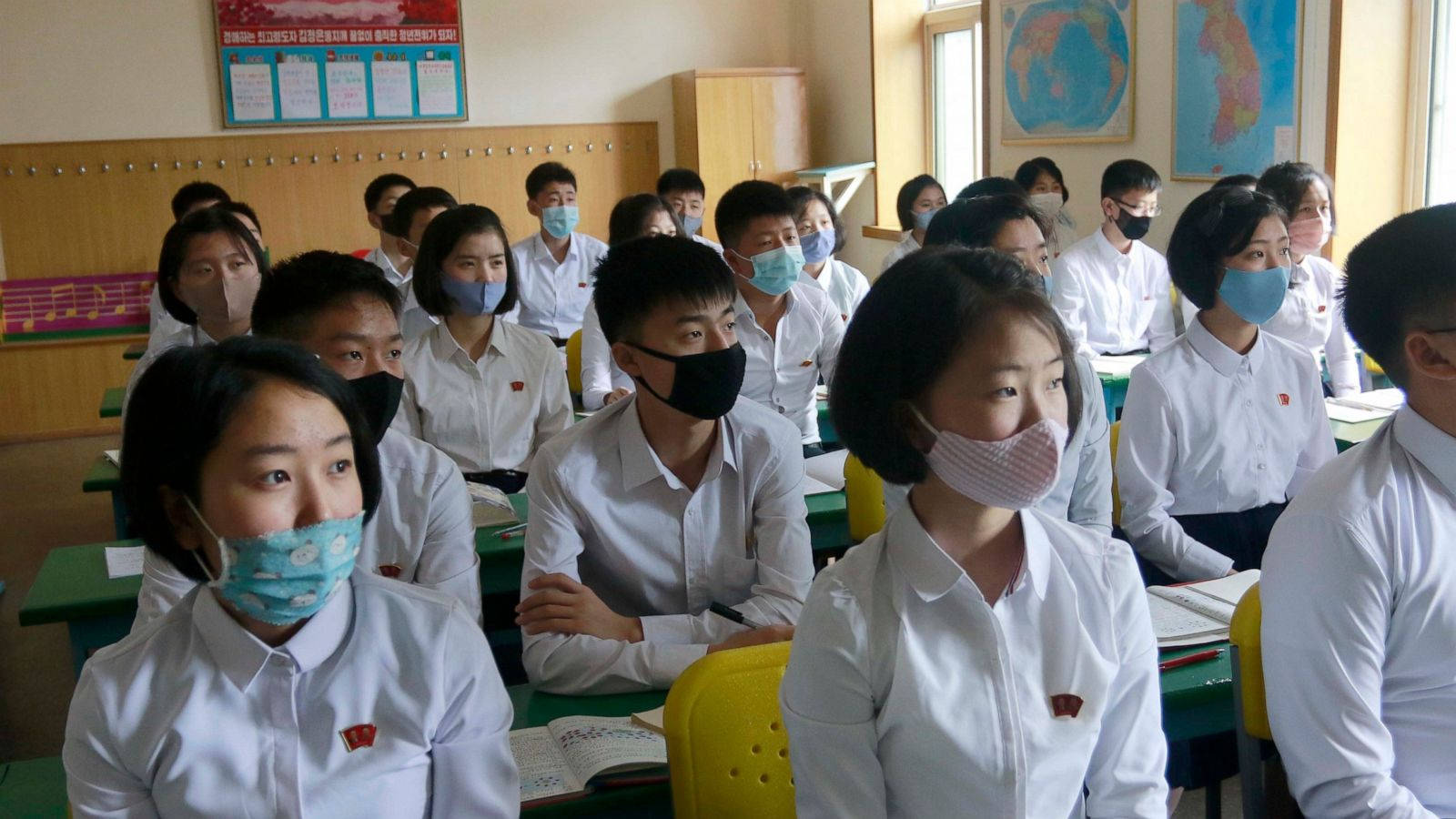 ผู้เชี่ยวชาญทางการแพทย์ในชุดป้องกันถือชุดทดสอบไวรัสโคโรนา วอลเปเปอร์