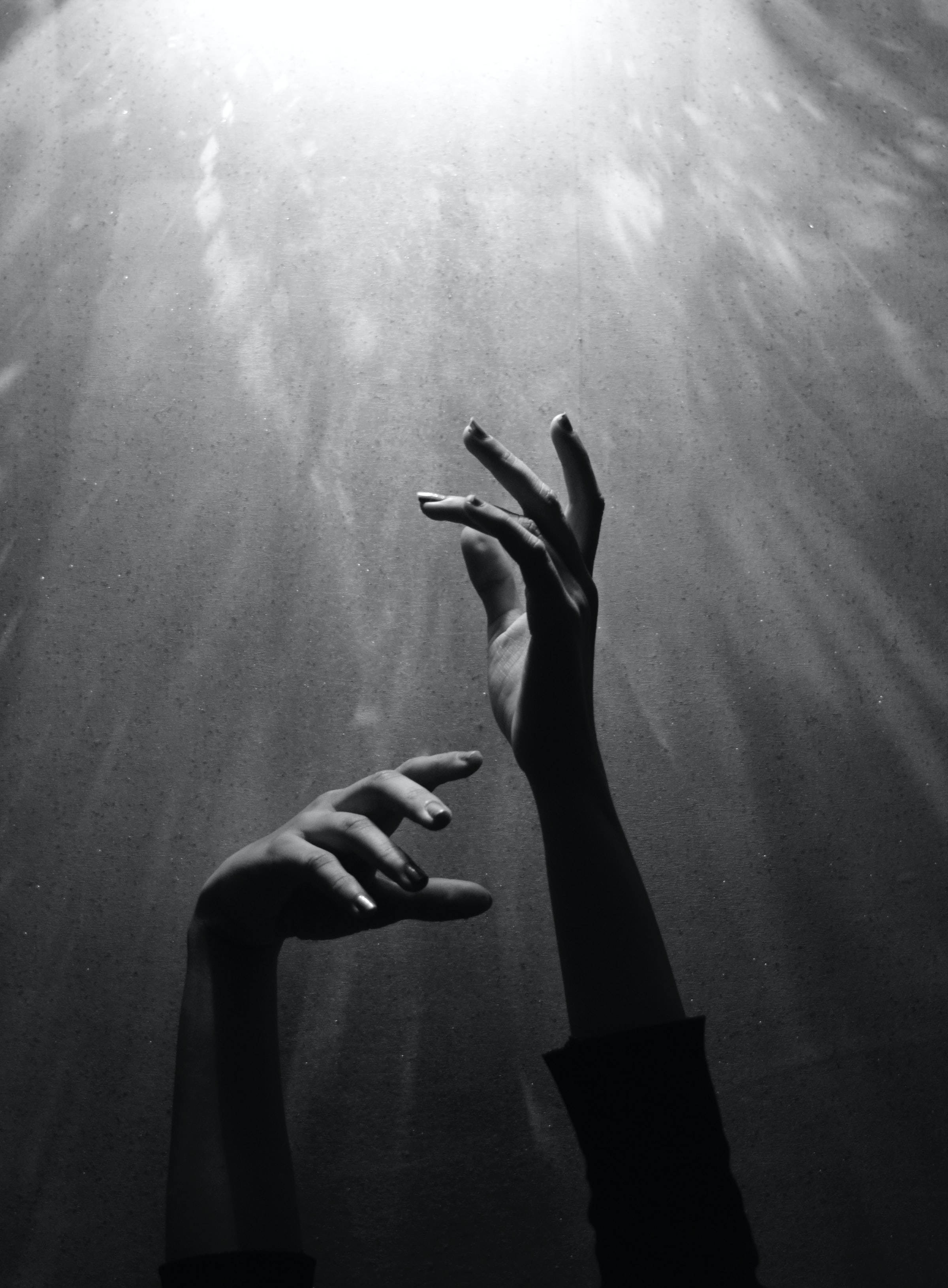 ภาพขาวดำของมือที่เอื้อมไปหาแสง วอลเปเปอร์