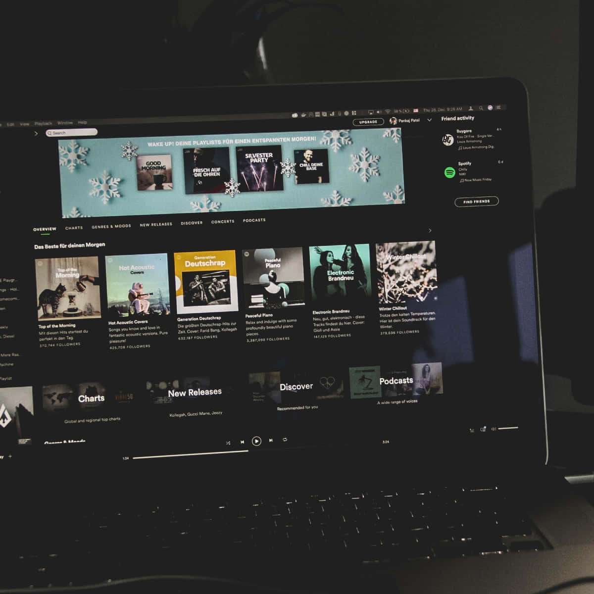 ภาพถ่ายมืดของแล็ปท็อปกับปกเพลย์ลิสต์ Spotify วอลเปเปอร์