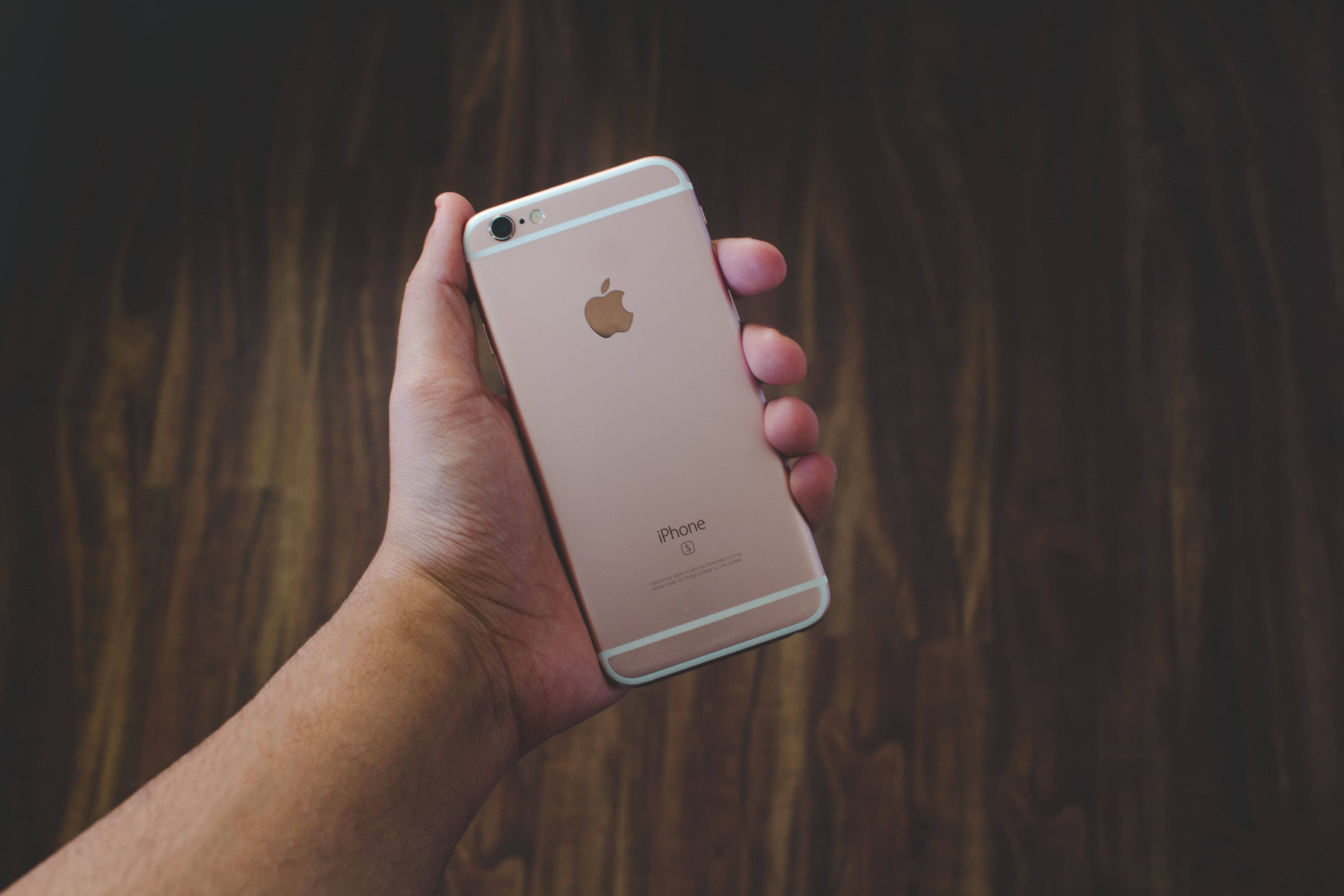 มือถือ iPhone 6 สีกุหลาบทองในมือ วอลเปเปอร์