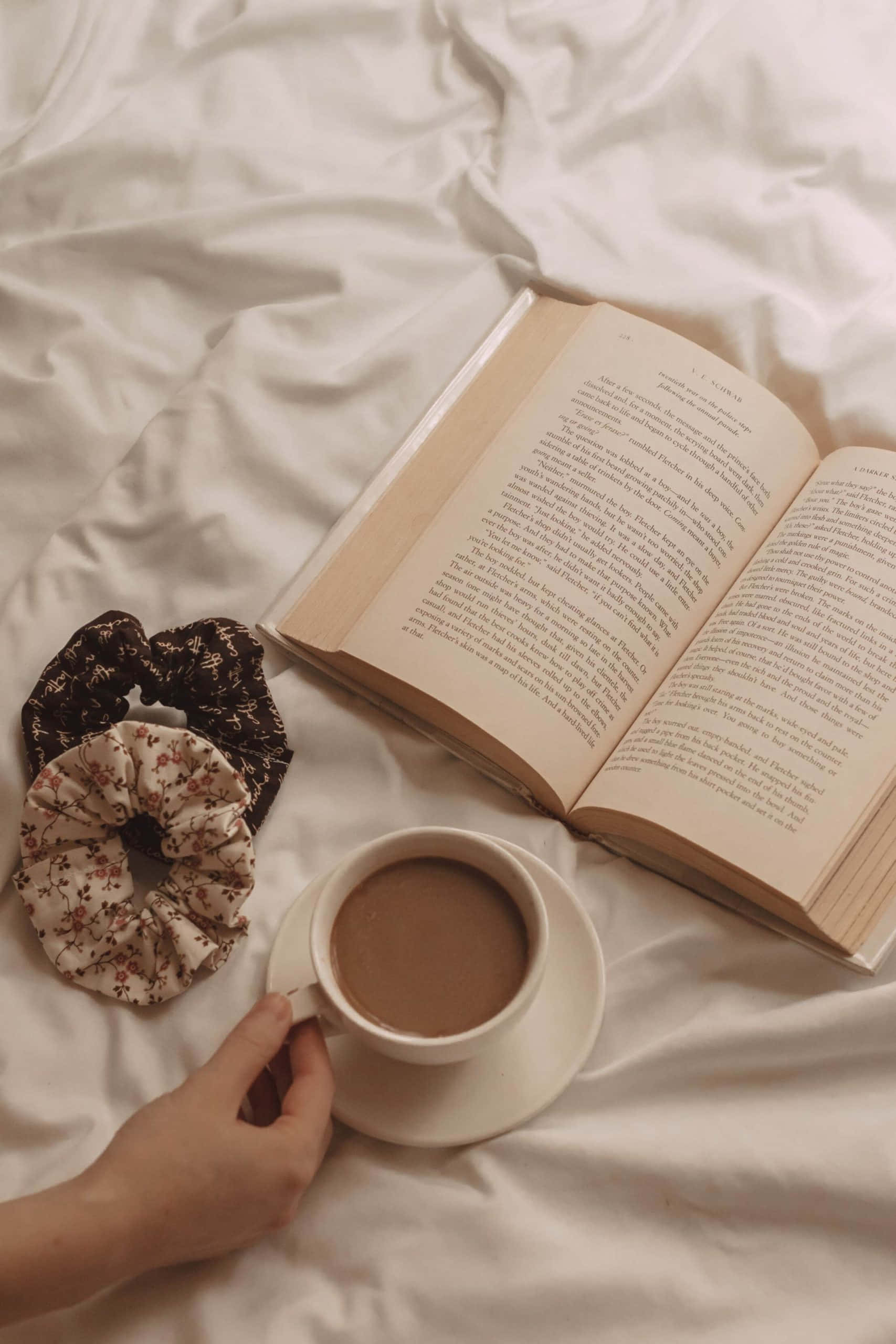 มือผู้หญิงถือหนังสือและถ้วยกาแฟ วอลเปเปอร์