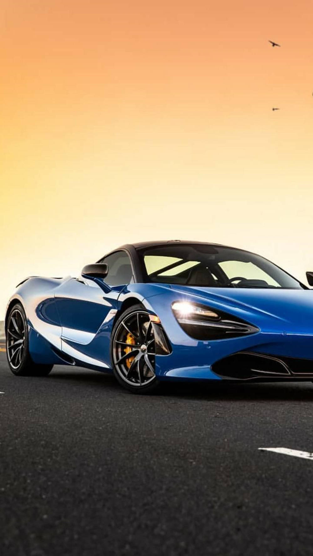 รถ McLaren 720S สีฟ้าภายใต้แสงอาทิตย์ตก วอลเปเปอร์