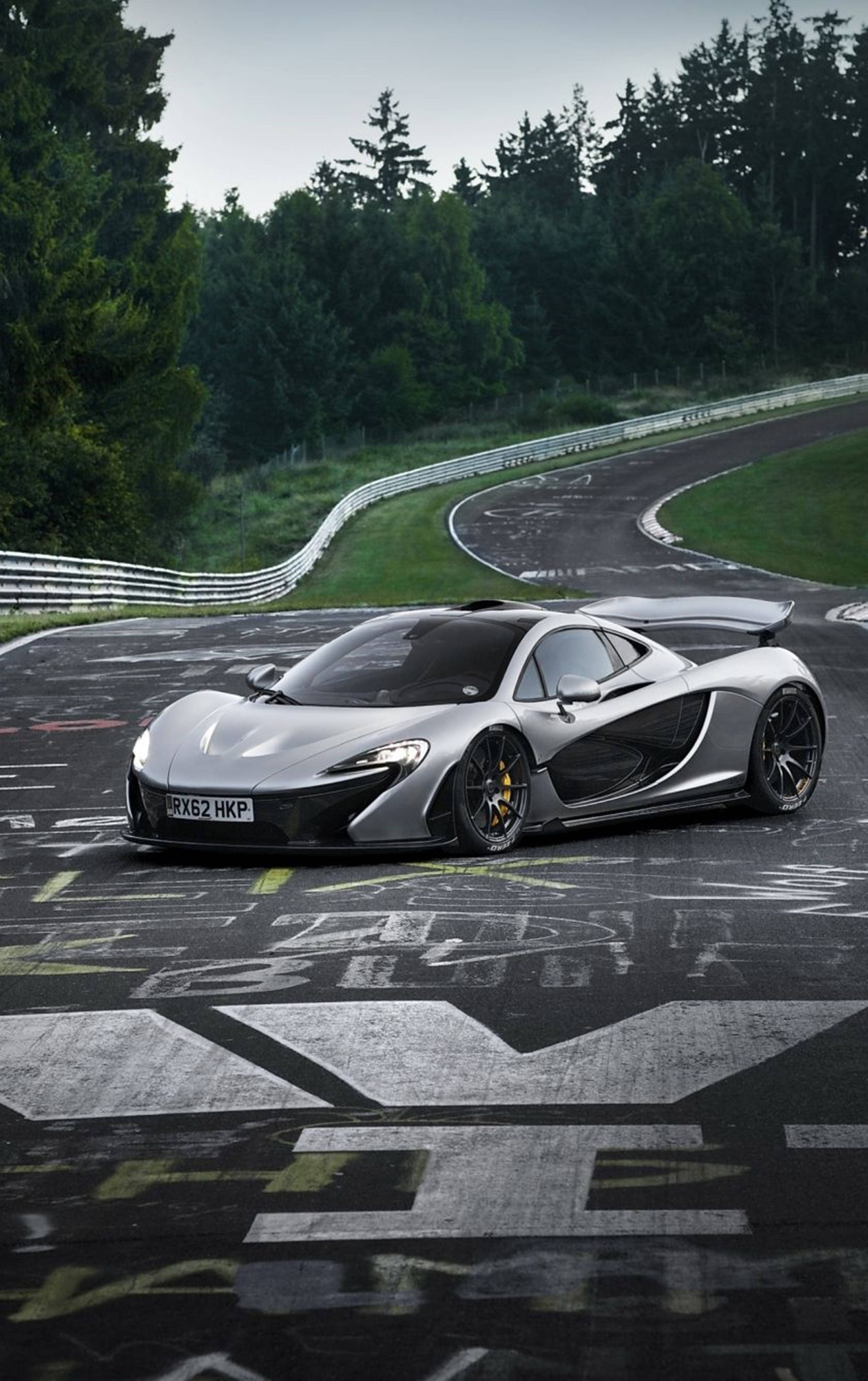 รถสปอร์ตสีขาวแล่นโค้งสนามแข่ง McLaren iPhone วอลเปเปอร์