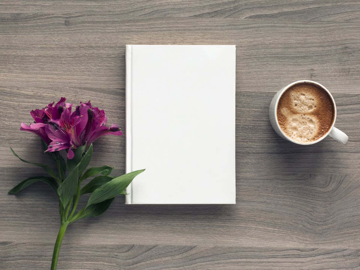 หนังสือสีขาวและกาแฟหนึ่งถ้วยบนโต๊ะไม้ วอลเปเปอร์