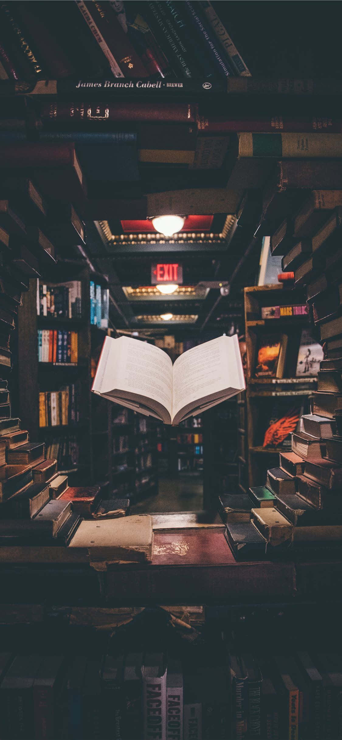 หนังสือเปิดบนชั้นวางในร้านหนังสือ วอลเปเปอร์