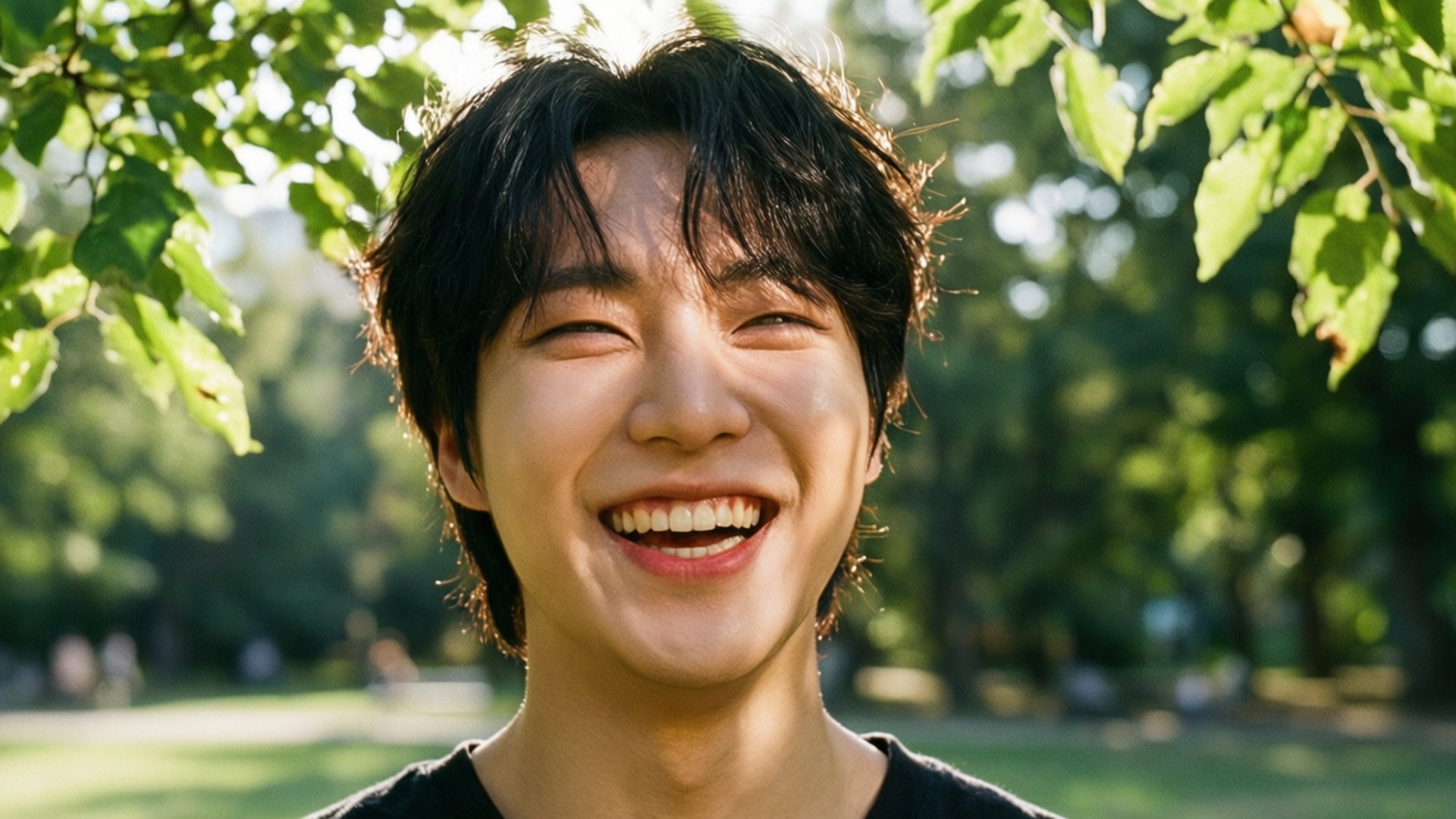 ภาพแคนดิดของฮันกำลังหัวเราะในสวนสาธารณะที่แสงแดดส่อง — Stray Kids วอลเปเปอร์