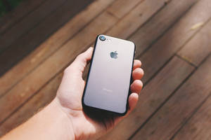 บุคคลถือ iPhone 7 สีดำด้าน