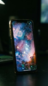 หน้าจอ iPhone 17 เรืองแสงพร้อมวอลเปเปอร์กาแล็กซี่ในความมืด