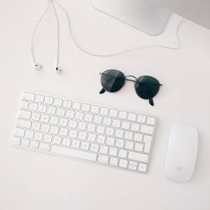 วอลเปเปอร์มินิมอลของชุด Apple MAC สีขาวประกอบด้วย iMAC คีย์บอร์ดไร้สาย Magic Mouse และหูฟัง — สะอาด วอลเปเปอร์