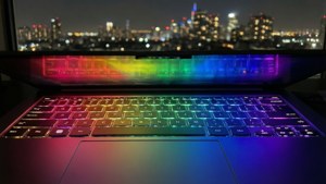 ภาพระยะใกล้ของคีย์บอร์ด Chromebook แสงไฟสีรุ้ง พร้อมวิวเมืองยามค่ำคืน — Chromebook วอลเปเปอร์