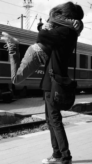 คู่รักน่ารักกอดกันข้างรถไฟขาวดำ