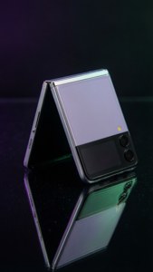 Z Flip 5 สุดหรูพับบนพื้นดำพร้อมประกายสะท้อนสีรุ้ง — ซี ฟลิป 5 วอลเปเปอร์