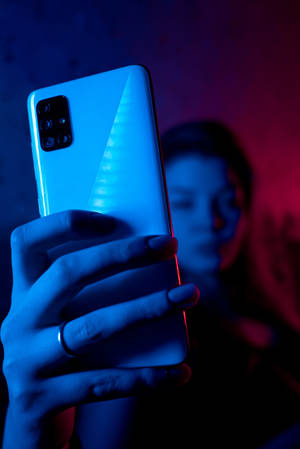 ผู้หญิงกับโทรศัพท์ในแสงนีออนสีน้ำเงิน iPhone — เสี่ยวหมี่ แท็บเล็ต 9 โปร แม็กซ์ วอลเปเปอร์