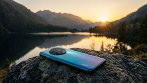 โทรศัพท์ Huawei บนก้อนหิน มองเห็นทะเลสาบภูเขาตอนพระอาทิตย์ตก ทิวทัศน์อันเงียบสงบ