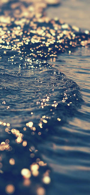 พระอาทิตย์ตกสวยงามที่ชายหาด — iPhone 15 วอลเปเปอร์
