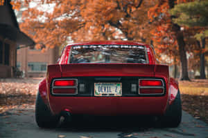 รถ Datsun สีแดงเพียวบางจอดบนถนนในเมือง — MacBook Air วอลเปเปอร์