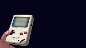 วอลเปเปอร์เครื่องเกม Nintendo Game Boy ยุคเรโทรที่ถือด้วยมือ