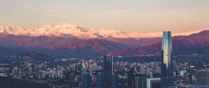 เส้นขอบฟ้าอุลตราไวด์มีตึกและภูเขาพร้อมแสงสะท้อนสีพาสเทล — 3440x1440 วอลเปเปอร์